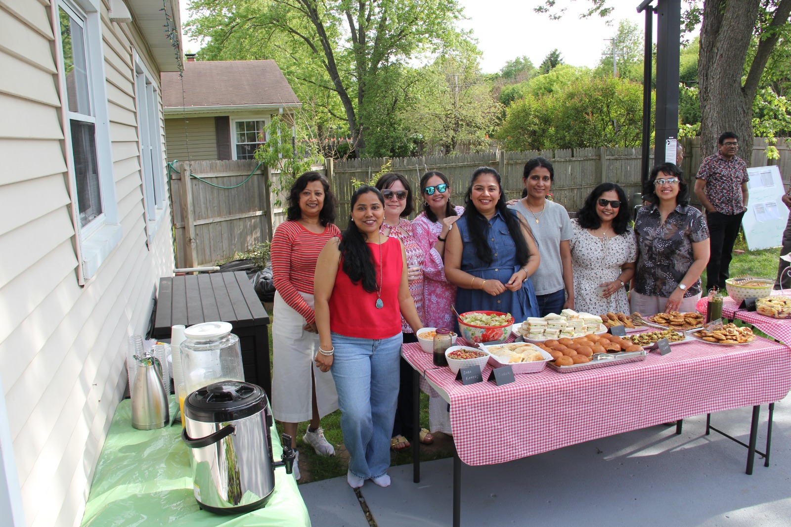 Eight women friends gathered along the full food and drink table for a group photo