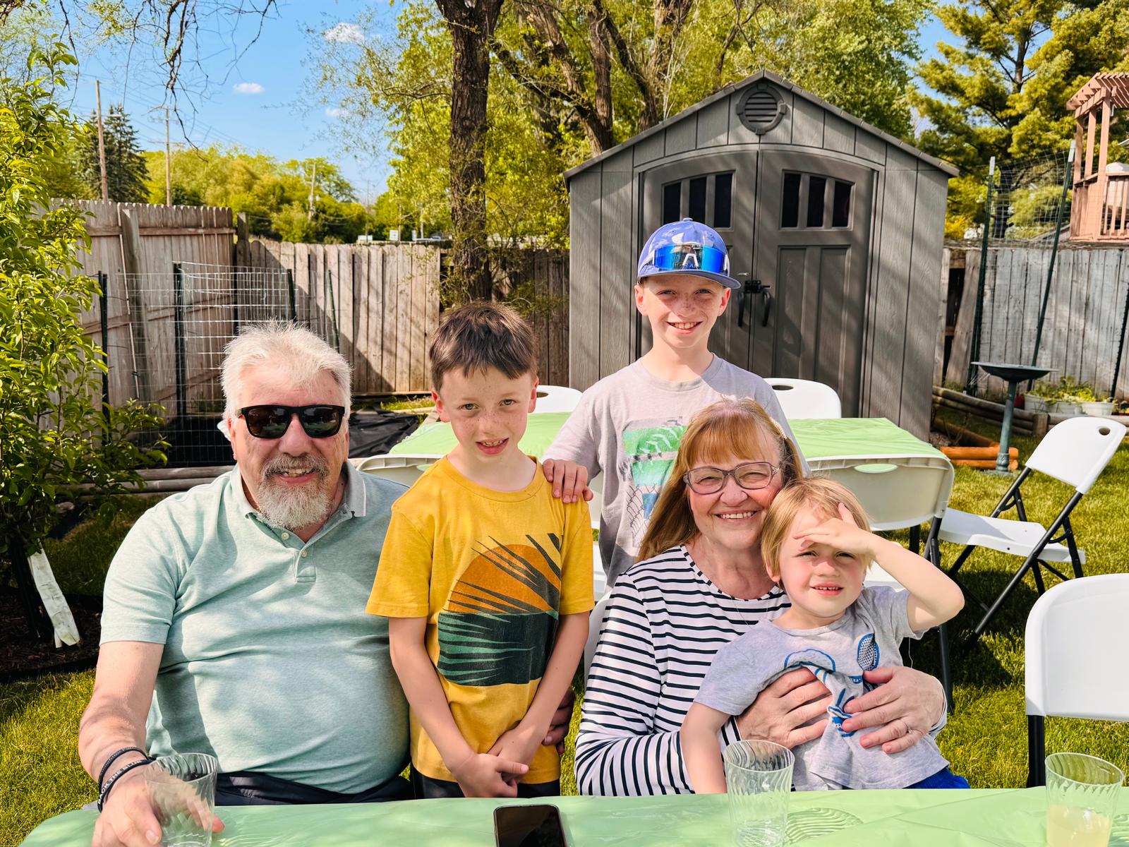 Family of guests posed together at the table with kids, grandparents, and green tablecloths