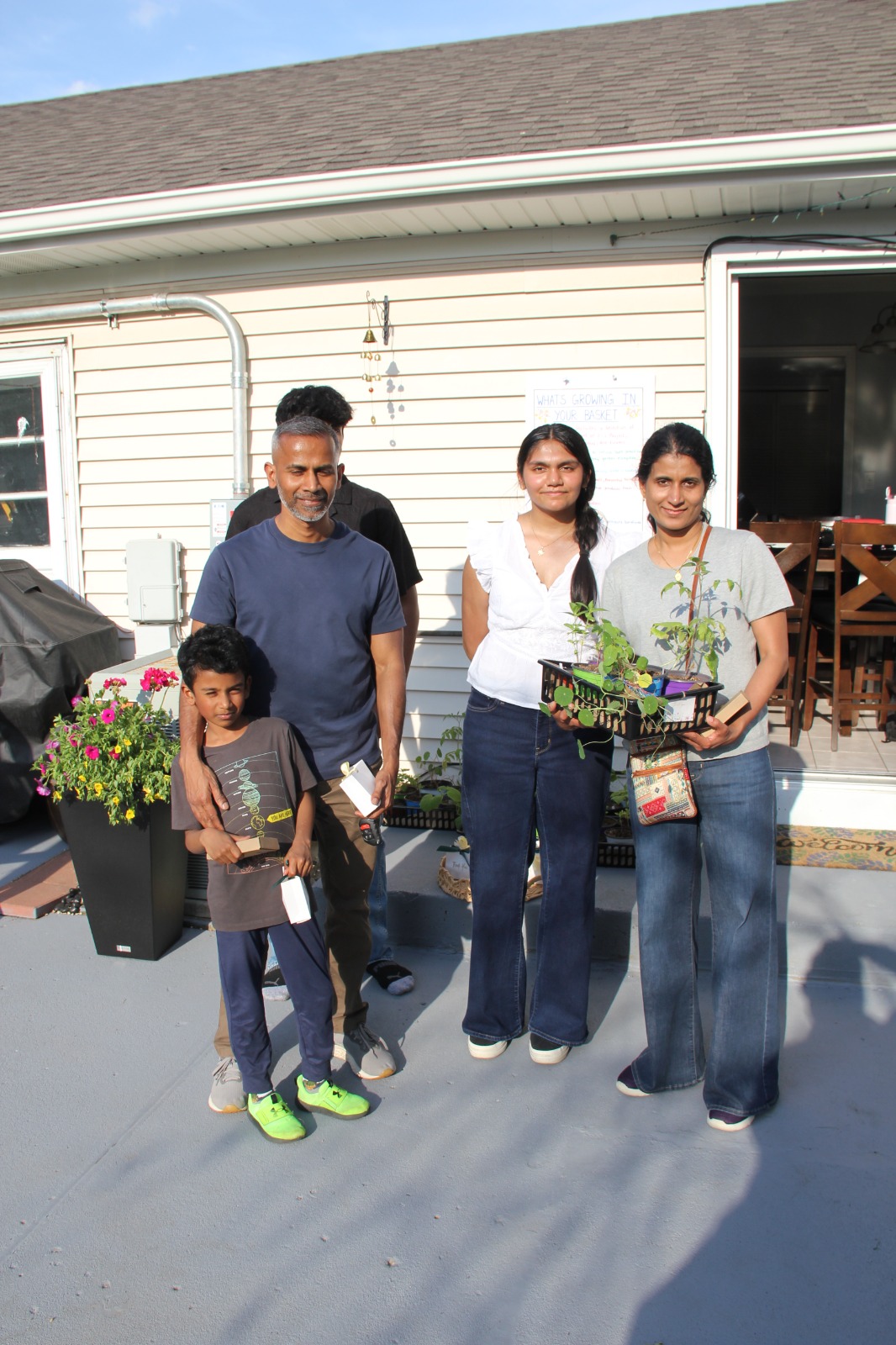 Guest family receiving their Seeds of Hope plant giveaway basket on the back patio